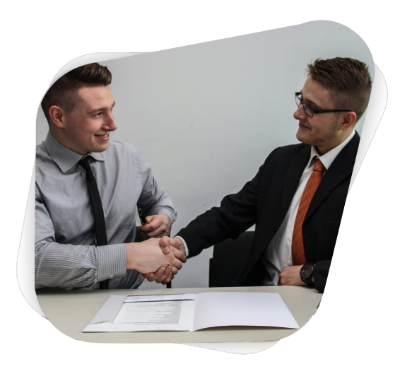 two men facing each other while shake hands and smiling